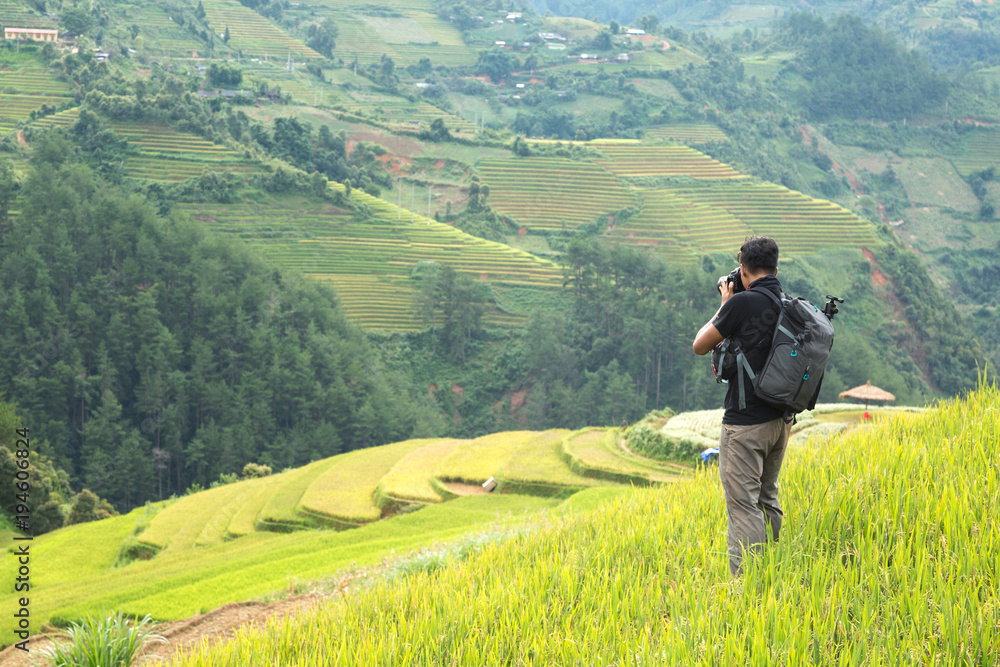 backpack photographer taking landscape photo of rice terrace in Vietnam