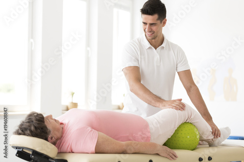 Physiotherapist supporting senior woman photo