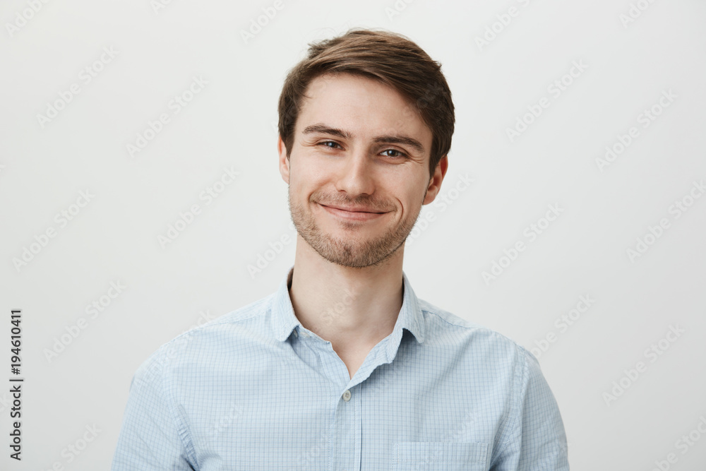 Keep talking but I do not care. Portrait of polite bothered attractive office worker in casual shirt pulling fake smile and trying to look friendly while standing over gray background, being annoyed Keep talking but I do not care. Portrait of polite bothered attractive office worker in casual shirt pulling fake smile and trying to look friendly while standing over gray background, being annoyed