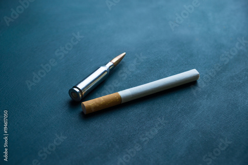 smoking shortens life. cigarettes on a dark background with a bullet