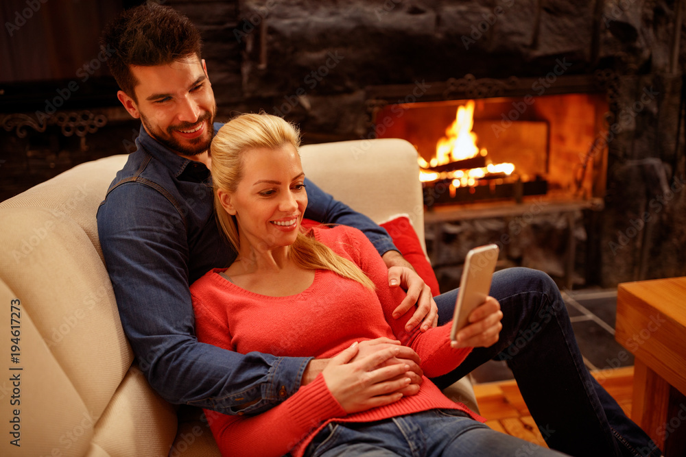 Young happy couple in love using mobile phone together Young happy couple in love using mobile phone together