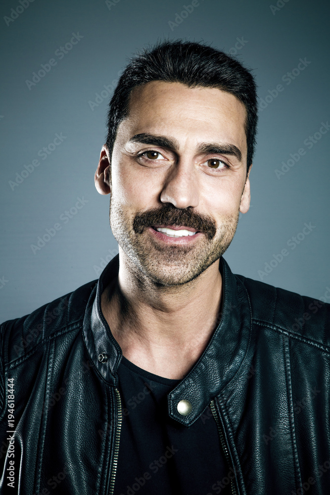 Fototapeta premium Young handsome man with beard and mustache studio portrait