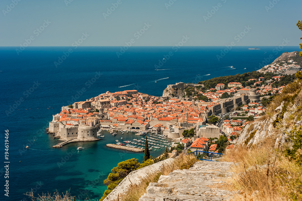 Spectacular picturesque view on the old town (medieval Ragusa) and Dalmatian Coast of Adriatic Sea. Picture taken from the mountain trails above Dubrovnik citadel, Famous European Travel Destination.