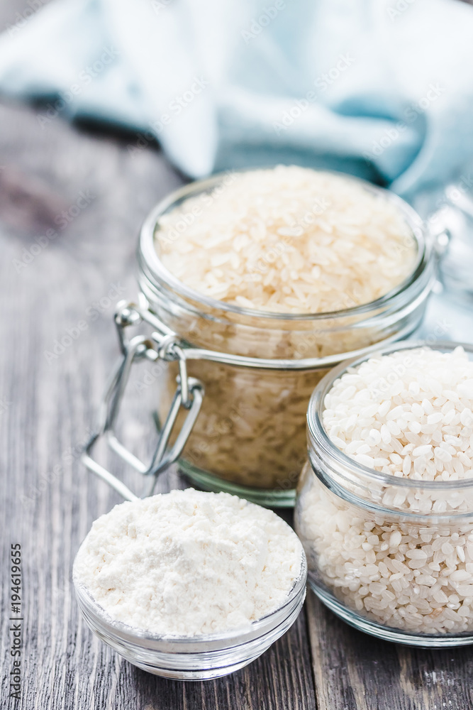 Rice and flour in glass jars on wooden rustic background. Selective focus, space for text. Rice and flour in glass jars on wooden rustic background. Selective focus, space for text.