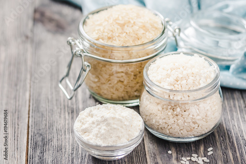 Rice and flour in jars on wooden background. Selective focus, space for text. 