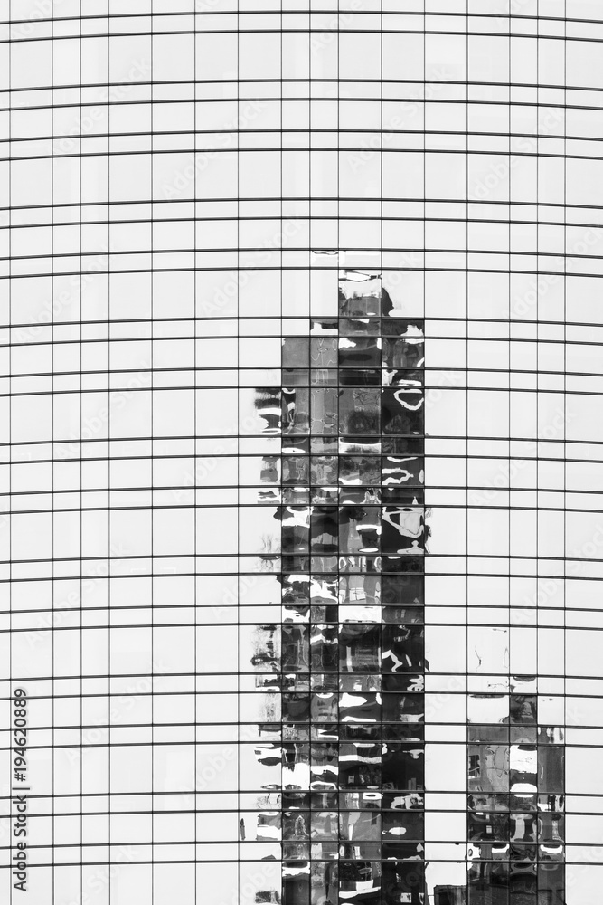 Obraz premium Reflection in the mirror of a modern glass skyscraper with geometric lines, Milan.