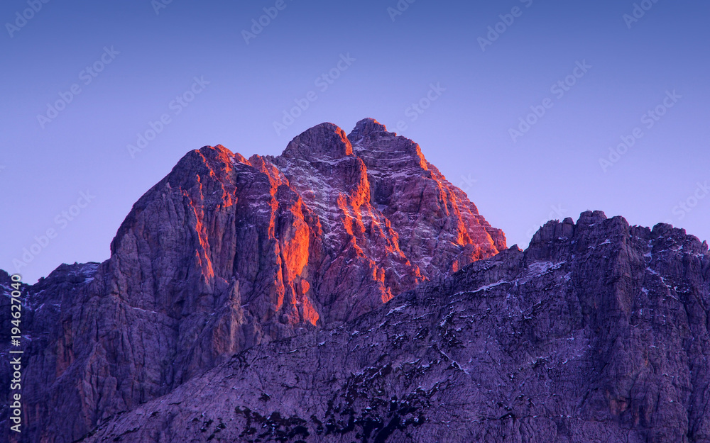 sunset light on Jof Fuart peak from Valbruna town. Julien Alps, Italy