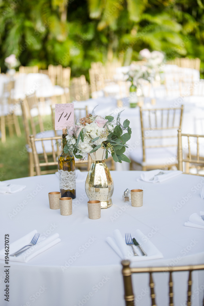 Gold and White Table Decor with Bouquet of Flowers and Wine Bottle Table Number Sign Gold and White Table Decor with Bouquet of Flowers and Wine Bottle Table Number Sign