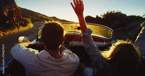 Driving into the sunset, romantic couple enjoying beautiful drive on country road photo