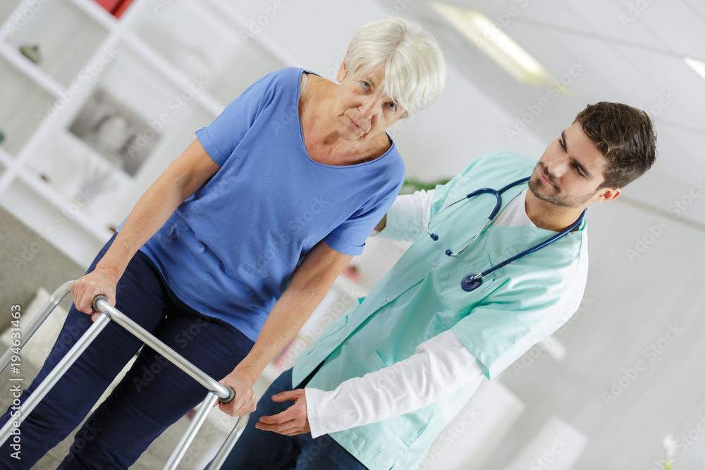 male nurse helping disabled elderly lady with a walking frame male nurse helping disabled elderly lady with a walking frame