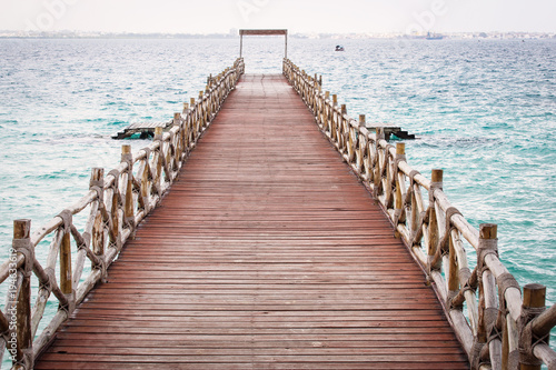 View of an empty bridge  over water.