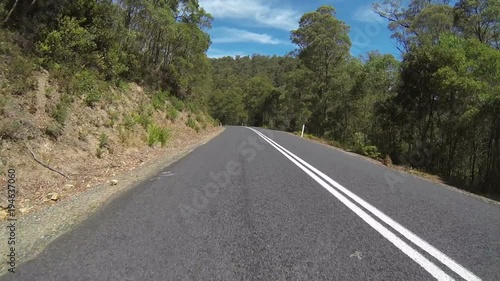 A car driving through a forest in Tasmania, Australia. Camera on front of car.