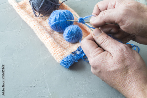 The man knits woolen clothes. Knitting needles. Close-up. natural wool
