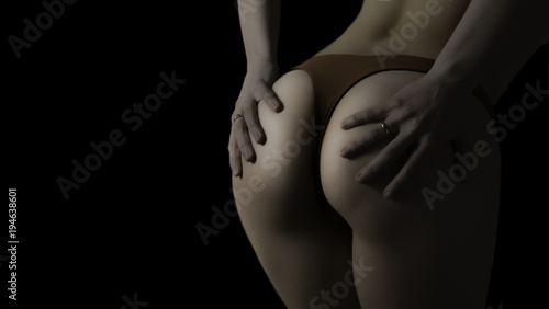 Butt of sexy woman's hips on black background