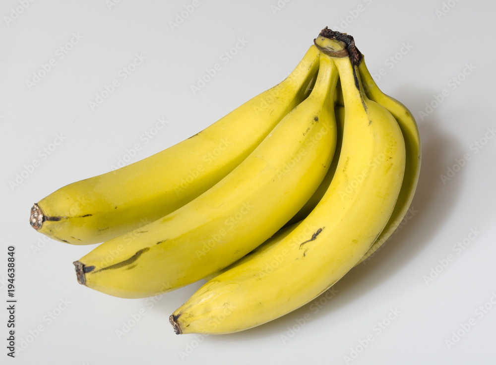 A beautiful bright yellow bunch of ripe bananas isolated on a white studio background. healthy vivid colours. A beautiful bright yellow bunch of ripe bananas isolated on a white studio background. healthy vivid colours.