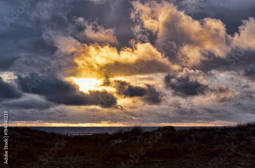 Sunset on the Atlantic coast, the clearing clouds in the sky, the silhouette of the kite.