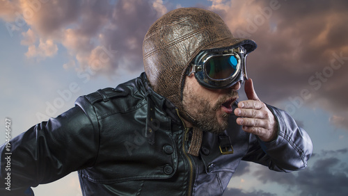 Accident, pilot of the 20s with sunglasses and vintage aviator helmet. Wears leather jacket, beard and expressive faces