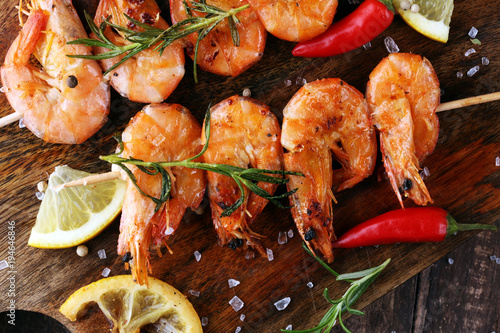 Grilled shrimp skewers. Seafood, shelfish. Shrimps Prawns skewers with herbs, garlic and lemon. photo