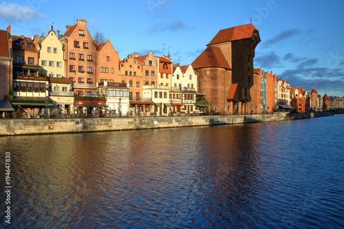 Panoramiczny widok na zabytkową architekturę Gdańska, Wielki Żuraw, historyczne kamieniczki nad rzeką Motławą, słoneczny dzień