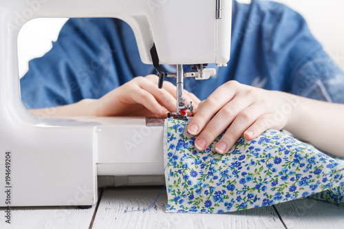 Woman hand sewn fabric on sewing machine.