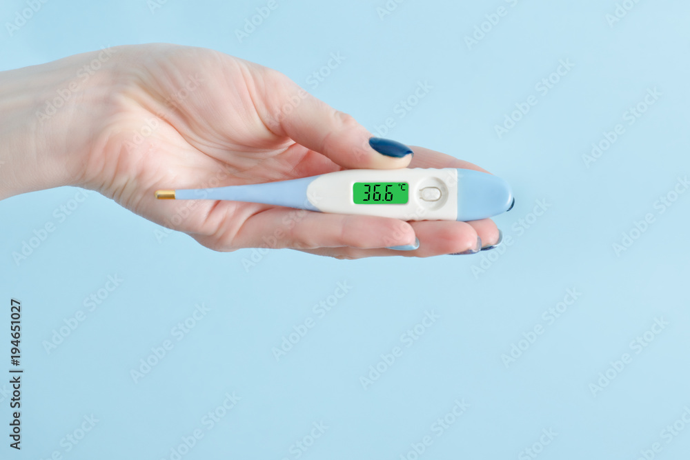 Electronic thermometer in a female hand. Normal temperature. Close up