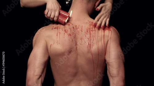 Dripping wax on a male body