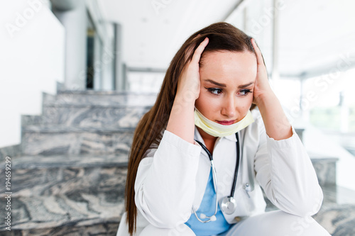 Fotografie Young female doctor has headache