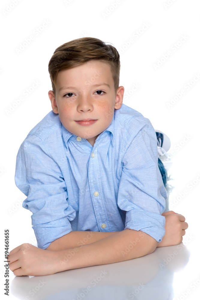 A teenager boy lies on a white background. A teenager boy lies on a white background.