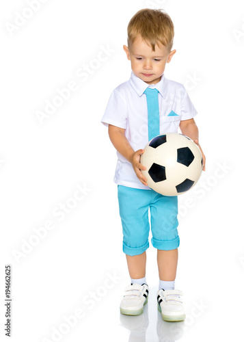 A little boy is playing with a ball. © lotosfoto