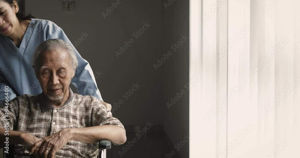 Female nurse pushing an old man on wheelchair near the window in the hospital. Shot in 4k resolution Female nurse pushing an old man on wheelchair near the window in the hospital. Shot in 4k resolution