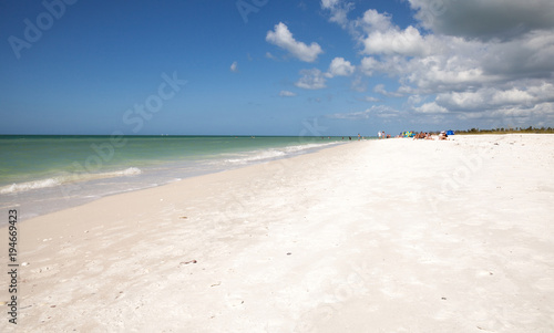 Blue sky over white sand and green beach grass of Tigertail Beach photo