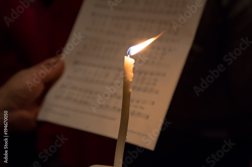 Single candle against sheet music