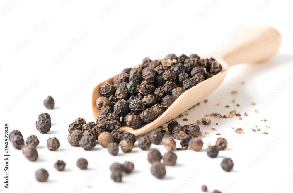 Dry black pepper on wood scoop isolated Dry black pepper on wood scoop isolated