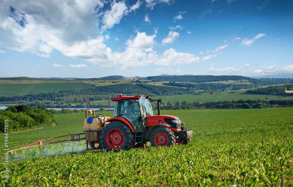 Naklejka premium Red tractor and beautiful clouds.