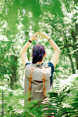 Hiker woman making heart shape with her hands outdoor. © Alex Photo