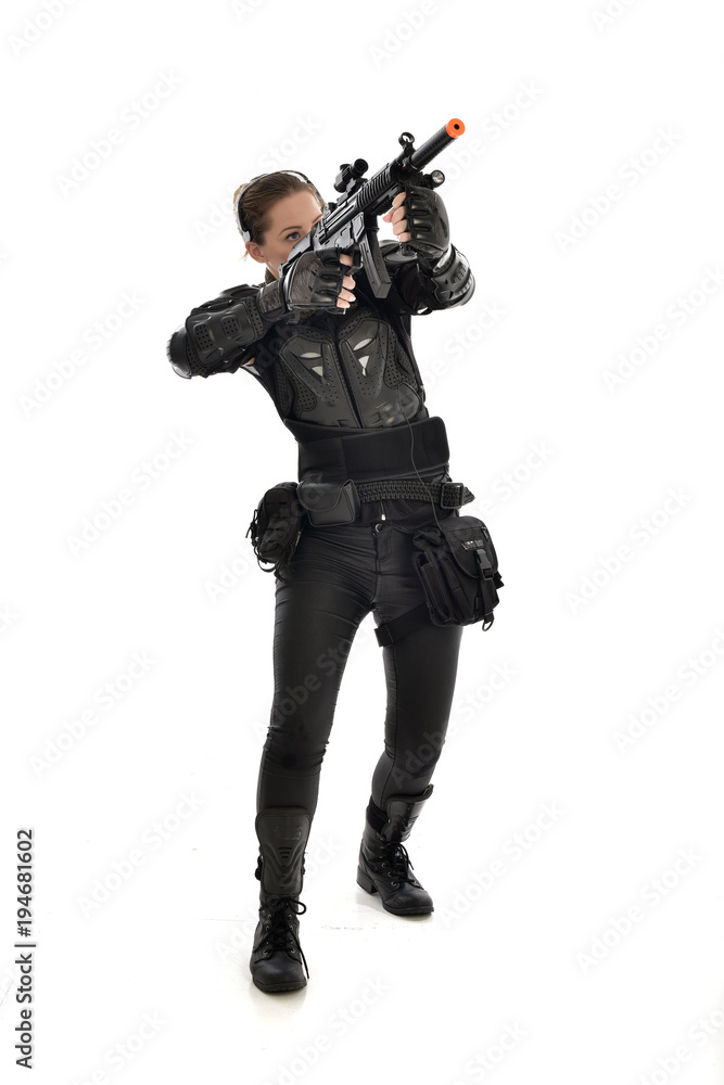 full length portrait of female soldier wearing black tactical armour, holding a rifle gun, isolated on white studio background. full length portrait of female soldier wearing black tactical armour, holding a rifle gun, isolated on white studio background.