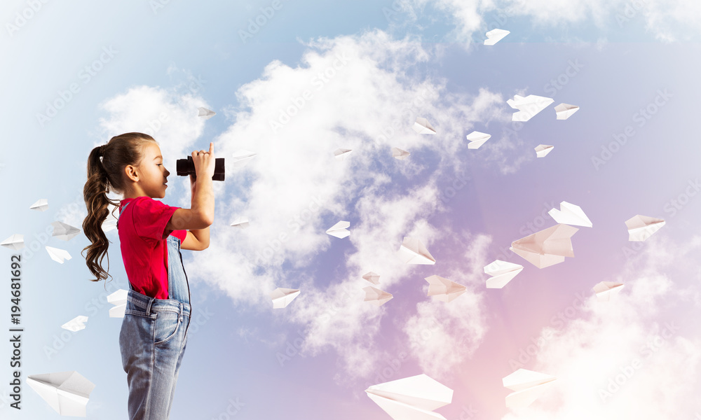Concept of careless happy childhood with girl looking in binoculars Concept of careless happy childhood with girl looking in binoculars