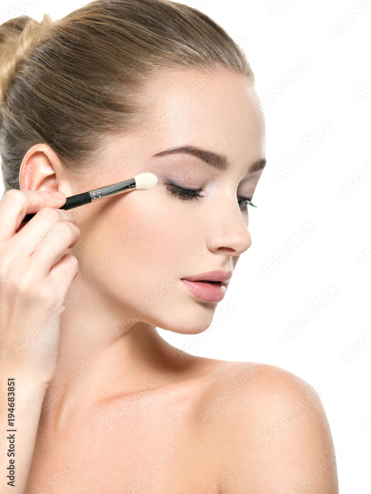 Girl makes makeup. Woman applies makeup shadow on the eyelid