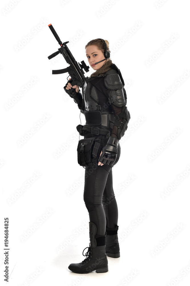 full length portrait of female soldier wearing black tactical armour, holding a rifle gun, isolated on white studio background. full length portrait of female soldier wearing black tactical armour, holding a rifle gun, isolated on white studio background.