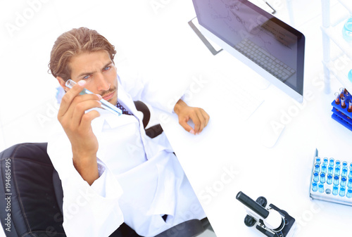 scientific researcher looking at a test tube of blue liquid