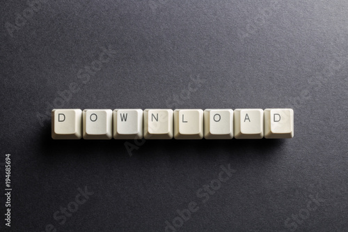 Word download made using computer keyboard buttons on a black background. Receive data from a remote system. IT technology concept.