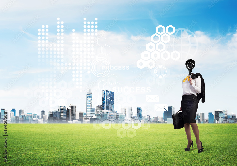 Camera headed woman standing on green grass against modern cityscape Camera headed woman standing on green grass against modern cityscape