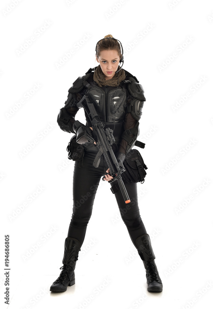 full length portrait of female soldier wearing black tactical armour, holding a rifle gun, isolated on white studio background. full length portrait of female soldier wearing black tactical armour, holding a rifle gun, isolated on white studio background.