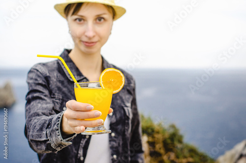 Diet. Healthy eating. Smiling woman holding lemonade drink in glass background sea wild nature outdoor beach cocktail. Fresh detox vegetable orange juice. Healthy lifestyle, vegetarian food.