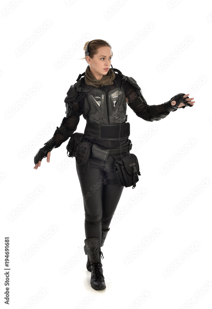 full length portrait of female soldier wearing black tactical armour, holding a rifle gun, isolated on white studio background. full length portrait of female soldier wearing black tactical armour, holding a rifle gun, isolated on white studio background.