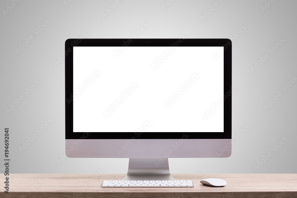 Modern desktop computer on wooden table. Studio shot isolated on blank grey. Blank screen for graphics display montage