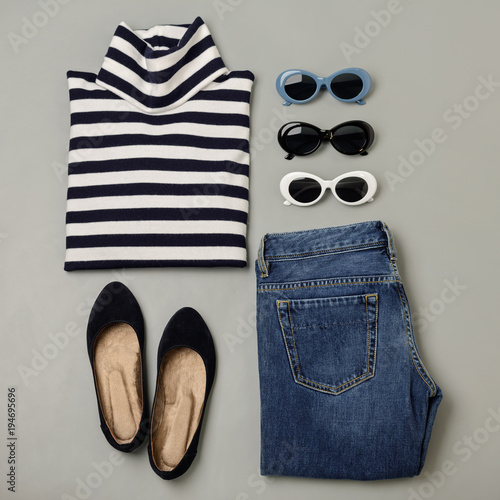 Fashion set of blue jeans, striped sweater, shoes and sunglsses. Flat lay.