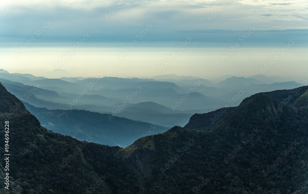 Fototapeta premium Sunrise in meadows and mountains landscape, Worlds End in Horton Plains National Park Sri Lanka.