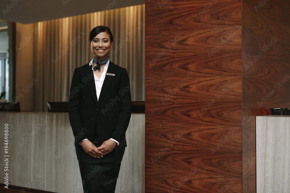 Female receptionist standing at hotel front desk Stock Photo  Adobe Stock