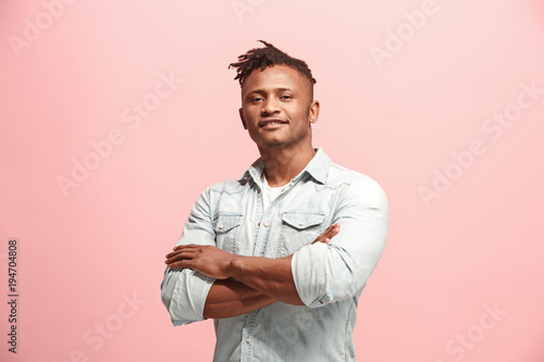 The happy business man standing and smiling against pink background. © master1305